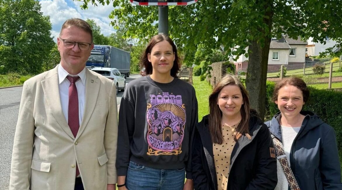 Der Bürgermeister von Waldkappel, Frank Koch, und die Abgeordnete Karina Fissmann, begleitet von zwei Elternteilen, vor dem neu installierten Geschwindigkeitsanzeigegerät EVOLIS Vision in Bischhausen.