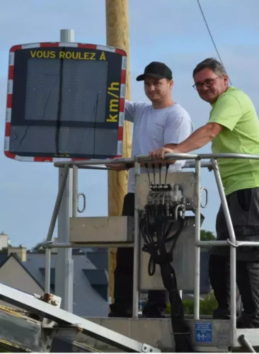 Des agents municipaux qui installent un radar pédagogique dans une rue communale à Plerneuf (22)