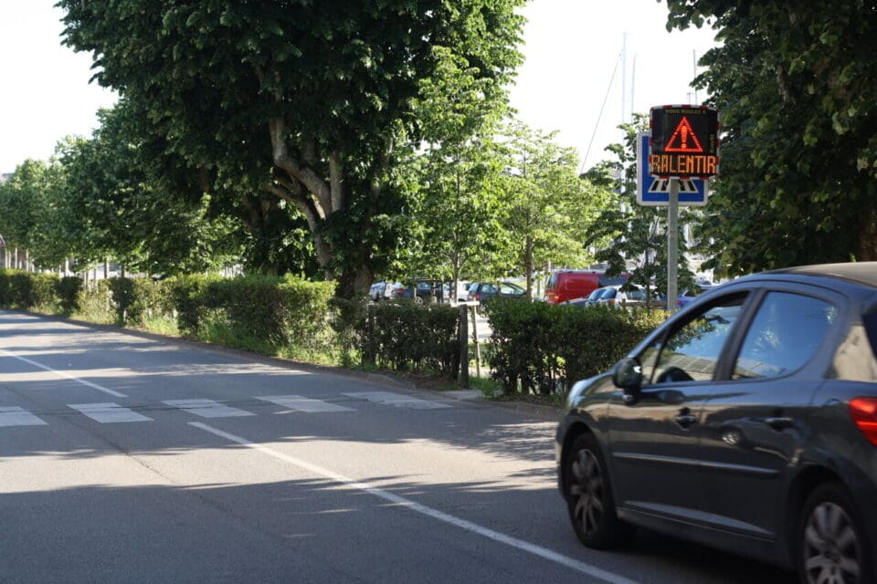 Radar pédagogique EVOLIS affichant le message 'RALENTIR' à l'approche d'une voiture sur une route à Vannes.