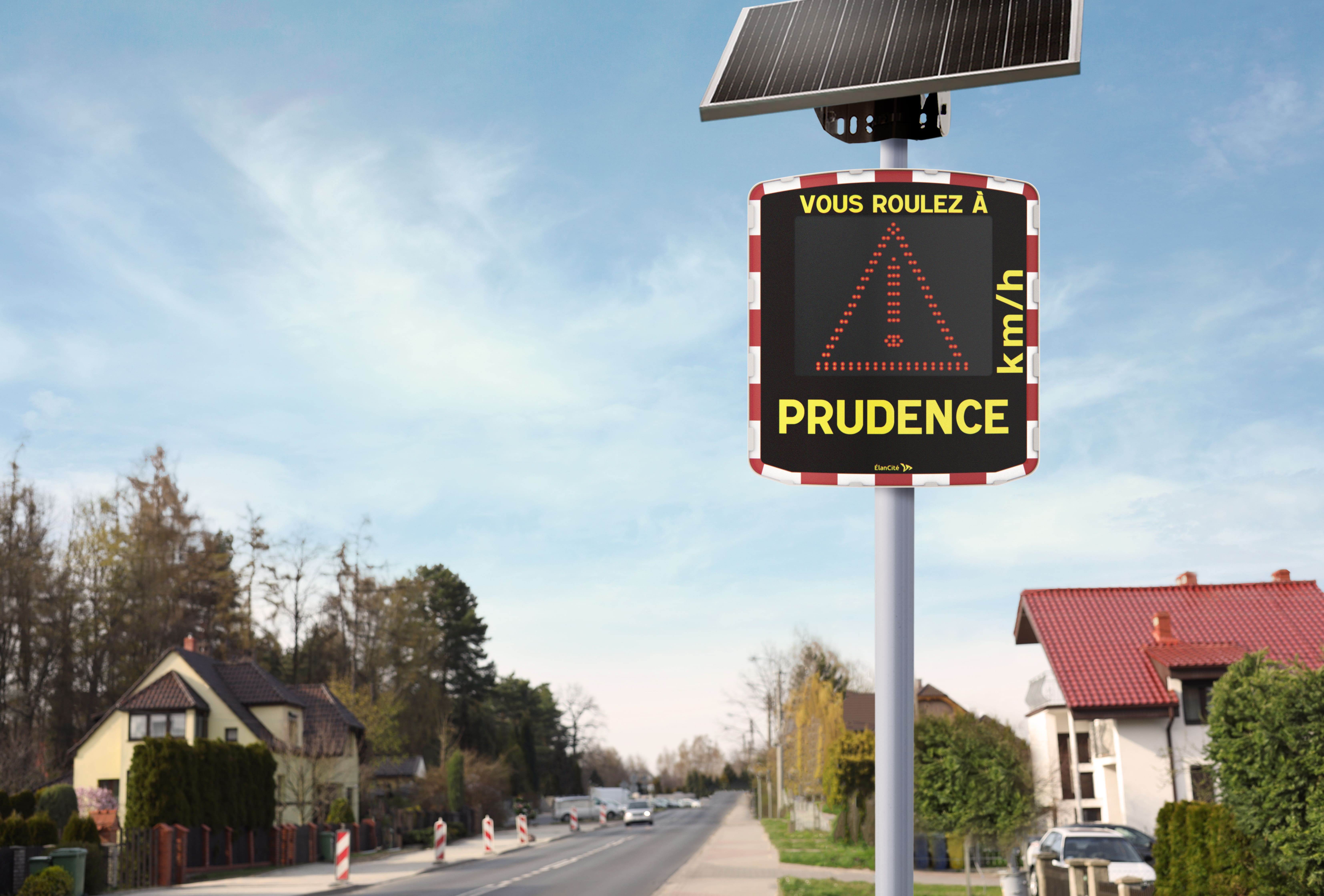 Un radar pédagogique mobile installé aux abords d'une rue pavillonnaire et qui affiche un triangle danger.