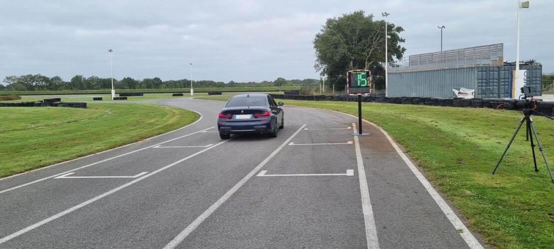 Une voiture circulant sur une piste de karting avec un radar EVOLIS qui détecte la vitesse.